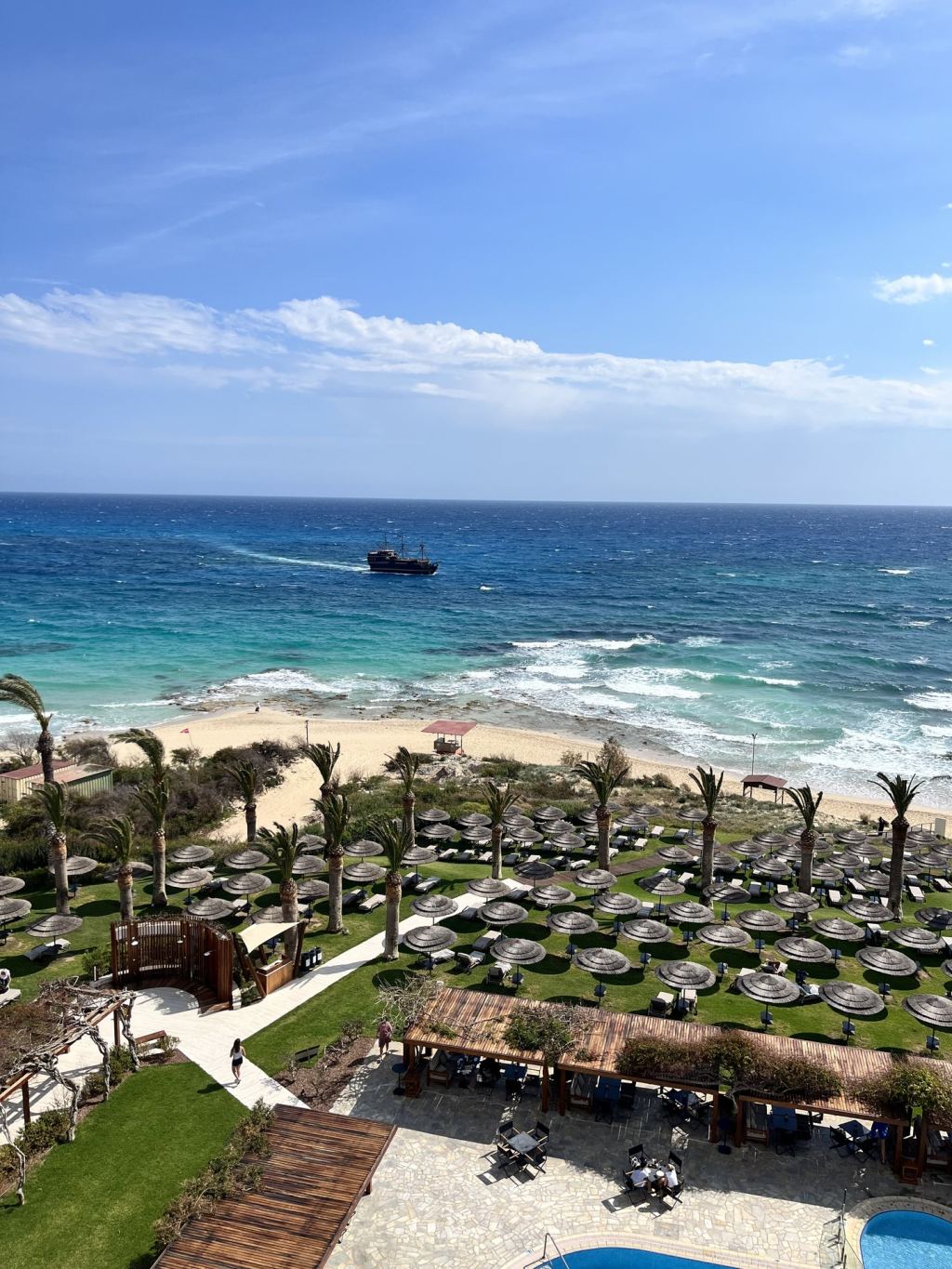 View from a balcony of the Alion Beach Hotel towards palm trees and the sea